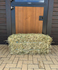 Small bale of Portuguese ryegrass hay in front of a stable door