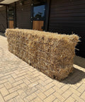 Big bale of Portuguese straw, roughly 300 kg, standing outside a stable block